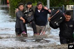 Seorang perempuan diselamatkan dari banjir di Melbourne, pinggiran Australia Maribyrnong, Jumat, 14 Oktober 2022.(Erik Anderson/AAP via AP)