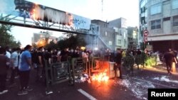 Demonstrators light a fire during a protest over the death of Mahsa Amini after she was detained by Iran's notorious morality police, in Tehran, Sept. 21, 2022. (West Asia News Agency via Reuters)