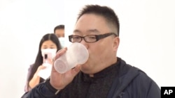 Seorang pria menghirup vaksin COVID aerosol yang dikembangkan oleh perusahaan biofarmasi China CanSino Biologics Inc. di Shanghai pada Rabu, 26 Oktober 2022. (Foto: Shanghai Media Group via AP)