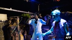 Patrick Kabré, artiste et co-fondateur du bar, signe sur la scène d'ouverture du bar "Le Procès", à Ouagadougou, le 8 octobre 2022.