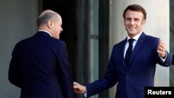 French President Emmanuel Macron welcomes German Chancellor Olaf Scholz before a meeting at the Elysee Palace in Paris, France, October 26, 2022.