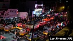Ambulans dan petugas SAR berdatangan untuk menolong korban cedera akibat berdesakan di lokasi pesta Halloween in Seoul, Korea Selatan, Minggu, 30 Oktober 2022. (Foto: Lee Jin-man/AP)