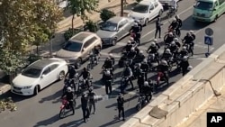 This image from a video taken by an individual not employed by the AP and obtained outside Iran shows police arriving to disperse a protest to mark 40 days since the death of Mahsa Amini, in Tehran, Oct. 26, 2022.