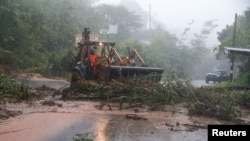 A tractor cleans a landslide near the scene where soldiers were killed in a landslide during the impact of the Tropical Storm Julia that hit with wind and rain, in Comasagua, El Salvador, Oct. 10, 2022. 