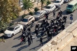 In this frame grab from video taken by an individual not employed by the Associated Press and obtained by the AP outside Iran shows Iranian police arriving to disperse a protest to mark 40 days since the death in custody of 22-year-old Mahsa Amini, in Tehran, Iran, Oct. 26, 2022.