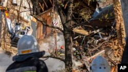 Firefighters work after a drone fired on buildings in Kyiv, Ukraine, Oct. 17, 2022. 
