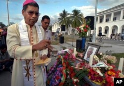 FILE - Uskup Katolik Roma Timor Lorosa'e dan penerima Hadiah Nobel Carlos Ximenes Belo berdoa dalam sebuah upacara untuk memberikan penghormatan terakhir kepada mantan kepala Badan Transisi PBB di Timor Lorosa'e, Sergio Vieira De Mello di Dili, pada 23 Agustus 2003. (AP/Firdia Lisnawati, File)