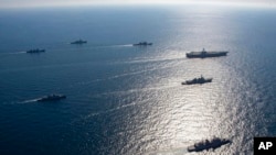 US aircraft carrier USS Ronald Reagan, top right, participates with other US and South Korean navy ships during the joint naval exercises between the United States and South Korea in waters off South Korea's eastern coast in South Korea, on Sept. 29, 2022