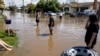 Local residents wade through floodwaters as the state of Victoria faces an ongoing flood crisis, in Shepparton, Australia, Oct. 16, 2022. (AAP Image/Diego Fedele via Reuters) 