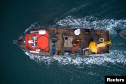 A boat transports a buoy to help avoid ship collisions with whales at the 'Corcovado' gulf area in the coast of Chiloe, Chile, October 10, 2022. (Fundacion MERI/Handout via REUTERS)