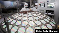 រូប​ឯកសារ៖ បុគ្គលិក​នៅ​រោងចក្រ​ផលិត​បន្ទះ​អេឡិចត្រូនិក semiconductor នៃ​ក្រុមហ៊ុន Jiangsu Azure Corp នៅ​ក្នុង​ខេត្ត Jiangsu ប្រទេស​ចិន កាល​ពី​ថ្ងៃ​ទី​២៥ ខែ​មីនា ឆ្នាំ​២០២២។