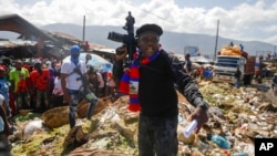 FILE - Barbecue, the leader of the G9 and Family gang, stands next to garbage to call attention to the conditions people live in as he leads a march against kidnapping through La Saline neighborhood in Port-au-Prince, Haiti, Oct. 22, 2021.