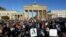 FILE - People gather in front of the Brandenburg Gate in Berlin, Oct. 7, 2022 to protest against the government in Iran in memory of Mahsa Amini, a young Iranian woman who died after being arrested in Tehran by Iran's 'morality police'. 