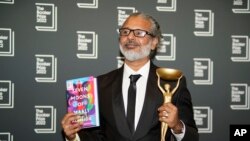 Writer Shehan Karunatilaka holds the Booker Prize after the announcement of the honor for his novel, "The Seven Moons of Maali Almeida" in London, Oct. 17, 2022. (AP Photo/Alberto Pezzali)