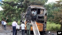 People inspect a bus that caught fire on a highway in Nashik, in the western Indian state of Maharashtra, Oct. 8, 2022.