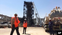 Workers stand at the Khurais oil field in Khurais, Saudi Arabia, Sept. 20, 2019. The OPEC+ coalition on Oct. 5, 2022, slashed production by 2 million barrels a day.