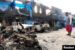 Seorang pria melihat kendaraan yang rusak di depan kantor Bea dan Cukai Indonesia setelah kerusuhan di Jayapura, Papua, 30 Agustus 2019. (Foto: Antara/Indrayadi TH via REUTERS)