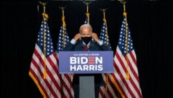 Democratic presidential candidate former Vice President Joe Biden removes his face mask as he arrives to speak at the Hotel DuPont in Wilmington, Del., Aug. 13, 2020.