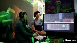 FILE - Gamers play Minecraft at the Paris Games Week (PGW), a trade fair for video games in Paris, France.