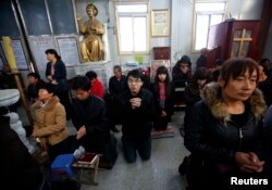 FILE - Believers take part in a weekend mass at an underground Catholic church in Tianjin .