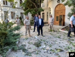 31일 러시아 흑해함대 본부에 드론 공격이 단행된 직후 파편이 흩어진 현장에 미하일 라즈보자예프(가운데) 세바스토폴 시장 등 관계자들이 서 있다. (라즈보자예프 시장 텔레그램)