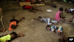 Anak-anak tidur di lantai sekolah yang diubah menjadi tempat penampungan, setelah mereka terpaksa meninggalkan rumah mereka di Cite Soleil akibat bentrokan antar geng bersenjata, di Port-au-Prince, Haiti, Sabtu, 23 Juli 2022. (Foto: AP)