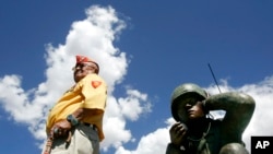 FILE - In this Sept. 8, 2004, photo, Navajo Code Talker Samuel Sandoval poses for pictures during a ceremony where the Oreland C. Joe Code Talker sculpture was unveiled at the Navajo Nation Fairgrounds in Window Rock, Ariz.
