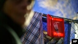 FILE - Prefilled syringes of naloxone to counter opioid overdoses are ready for use outside the gate where dozens of Native women are living in tents in the lot of an abandoned gas station in south Minneapolis, Nov. 15, 2021. 
