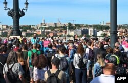 Peserta aksi protes memblokir lalu lintas di salah satu jembatan yang paling ramai di Budapest, Jembatan Margaret, 18 Juli 2022. (ATTILA KISBENEDEK / AFP)
