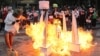 FILE - A model of the Democracy Monument built by activists is lit on fire outside the Constitutional Court of Thailand in Bangkok on November 10, 2021.