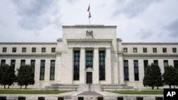 FILE - An American flag flies over the Federal Reserve Board Building in Washington, May 4, 2021.