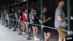People wait in line to receive the monkeypox vaccine before the opening of a new mass vaccination site at the Bushwick Education Campus in Brooklyn, New York, July 17, 2022.