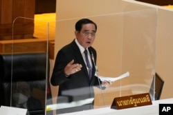 PM Thailand Prayuth Chan-ocha menjawab pertanyaan dalam debat terkiat mosi tidak percaya di Parlemen di Bangkok, Thailand, Selasa, 19 Juli 2022. (AP/Sakchai Lalit)
