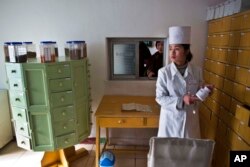 FILE - A pharmacist gathers traditional Koryo medicine for a patient at the Kaeson Clinic in the Moranbong District of Pyongyang, North Korea , Feb. 21, 2013.