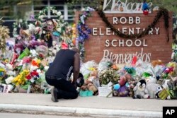 Reggie Daniels memberikan penghormatan di sebuah monumen peringatan di Robb Elementary School pada 9 Juni 2022, di Uvalde, Texas. (Foto: AP)