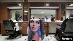 FILE - The morals police seal off a barber shop for giving Western-style haircuts in Tehran, June 16, 2008.
