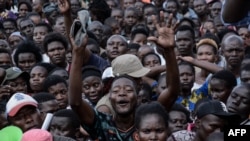 Les partisans des candidats aux sièges électifs locaux font la queue pour recevoir de l'argent lors d'un rassemblement politique à Kisumu, dans l'ouest du Kenya, le 16 juillet 2022.