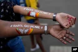 Girls display their arms painted with message "Ranil go home' referring to Prime Minister Ranil Wickremesinghe at the protest site in Colombo, Sri Lanka, July 17, 2022.