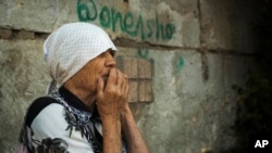 FILE - An elderly Ukrainian woman looks on after Russian shelling in Mykolaiv, Ukraine, June 29, 2022. Ukraine said on July 29, 2002, that at least five people had been killed and seven wounded in a Russian missile strike on the city.