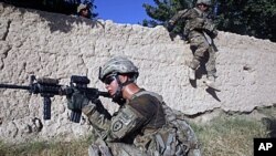 US Army soldiers from Charlie company 4th platoon,1st brigade 3-21 infantry, jump over a wall during a patrol in the village of Chariagen in the Panjwai district of Kandahar province southern Afghanistan . President Barack Obama unveiled his plan to start