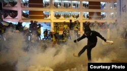 បាតុករ​ម្នាក់​ទាត់​កំពុង​ឧស្ម័ន​បង្ហូរ​ទឹក​ភ្នែក​អំឡុង​ការ​ប៉ះទង្គិច​ក្នុង​ហុងកុង​កាលពី​ថ្ងៃអាទិត្យ​ទី២១​ ខែកក្កដា ឆ្នាំ២០១៩។