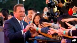 Actor and former Governor of California Arnold Schwarzenegger shakes hands with Chinese fans as he arrives for the grand opening of the 5th annual Beijing International Film Festival in Beijing, April 16, 2015. 