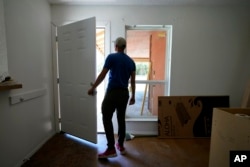 A rafter from Cuba who recently arrived in Miami illegally by sea, seeking to escape political and economic difficulties, is seen at a worksite, Wednesday, July 6, 2022, in Austin, Texas. (AP Photo/Eric Gay)
