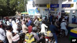 FILE - People wait in lines at a petrol station in Karachi, Pakistan, Nov. 25, 2021. Government officials blame the country’s economic woes on the global rise in the cost of food and fuel due to supply chain issues caused by the COVID-19 pandemic and Russia's war in Ukraine.