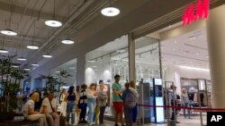 People line up to enter an H&M shop and buy items on sale in the Aviapark shopping mall in Moscow, Russia, Aug. 9, 2022.