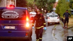 Vatrogasac prolazi pored pogrebnih kola na mjestu masovne pucnjave na Cetinju, 36 kilometara zapadno od Podgorice, Crna Gora, 12. avgusta 2022. 