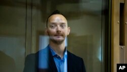 FILE - Ivan Safronov, an adviser to the director of Russia's state space corporation, stands in a cage in a courtroom in Moscow, July 16, 2020. 