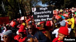 South Africans carry placards during a nationwide strike over the high cost of living, in Pretoria, South Africa, Aug. 24, 2022. 