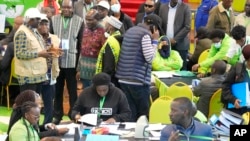 La présidente de la Commission électorale (IEBC), Wafula Chebukati, au milieu en chemise rouge, et les commissaires de l'IEBC au National Tallying Center à Bomas à Nairobi, au Kenya, le 14 août 2022.