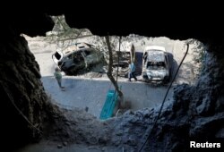 Local residents inspect cars destroyed by recent shelling in the course of Ukraine-Russia conflict in the Russian-controlled city of Enerhodar in Zaporizhzhia region, Ukraine, Aug. 30, 2022.
